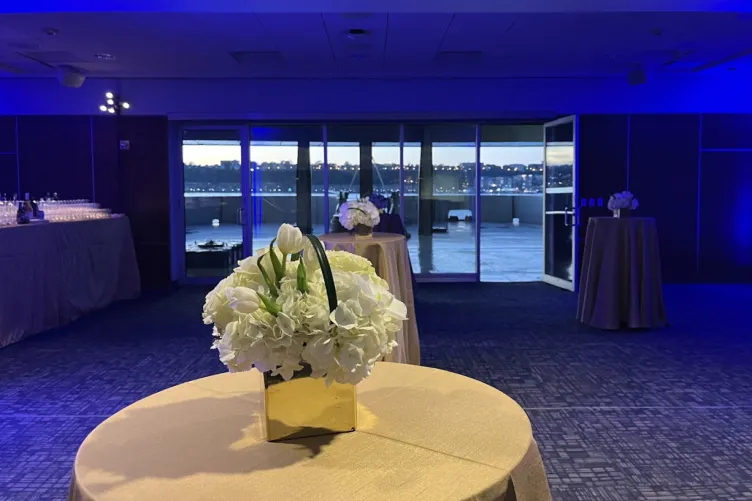 VIP Room cocktail reception with blue lighting and floral arrangements on cocktail tables