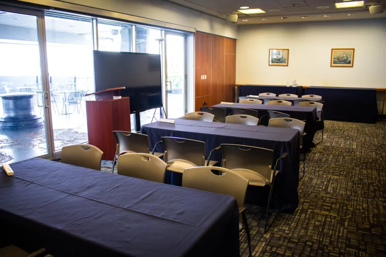 VIP Room setup for a meeting with podium, large monitor, and classroom style seating